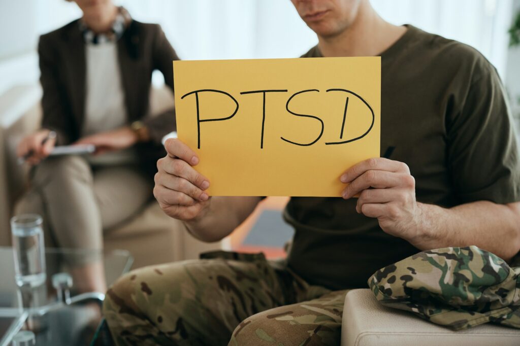 Close-up of veteran holding PTSD placard at mental health counseling center.